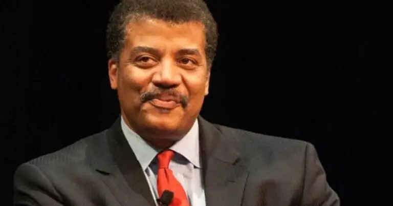 Neil deGrasse Tyson speaking at an event, showcasing his successful career and net worth.