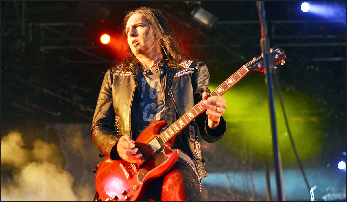 Damon Johnson performing live on stage with his guitar, showcasing his rock star persona.